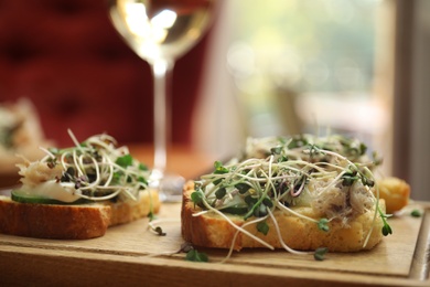 Delicious bruschettas with fish on table, closeup