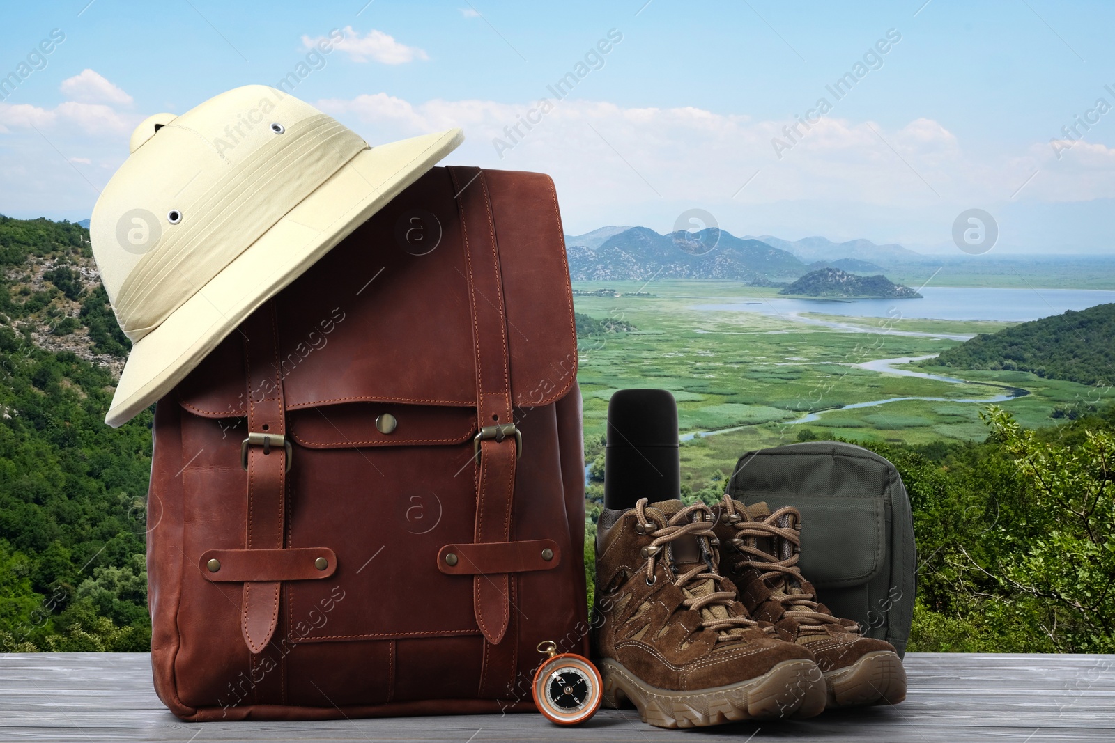 Image of Camping equipment for tourist on wooden surface and beautiful view of mountain landscape