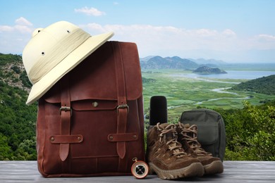 Image of Camping equipment for tourist on wooden surface and beautiful view of mountain landscape