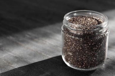 Photo of Glass jar with chia seeds on slate table. Space for text