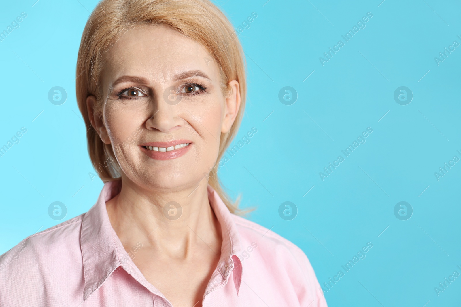 Photo of Portrait of mature woman with beautiful face on blue background. Space for text