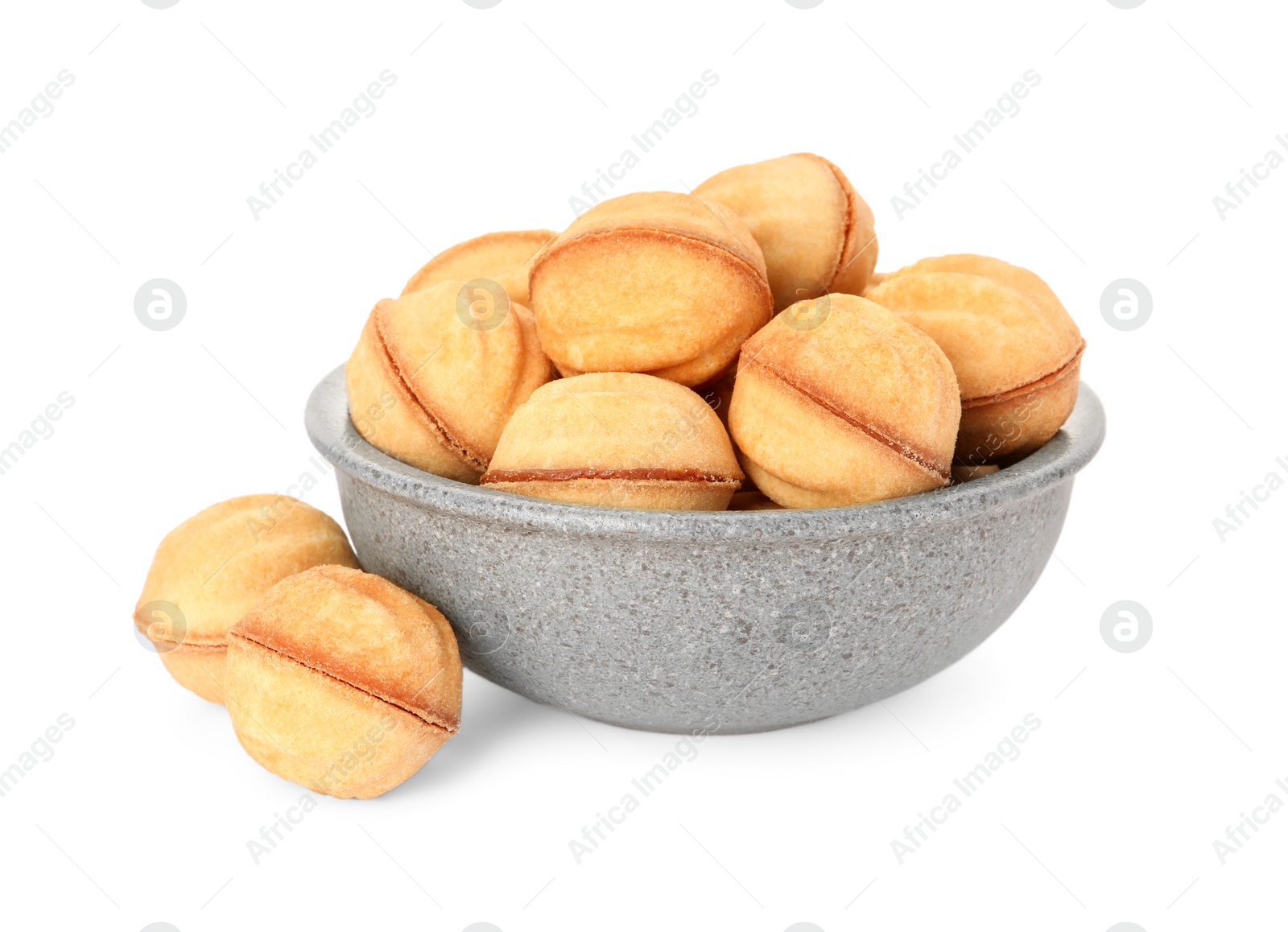 Photo of Bowl of delicious nut shaped cookies with condensed milk on white background