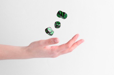 Woman throwing game dices on white background, closeup