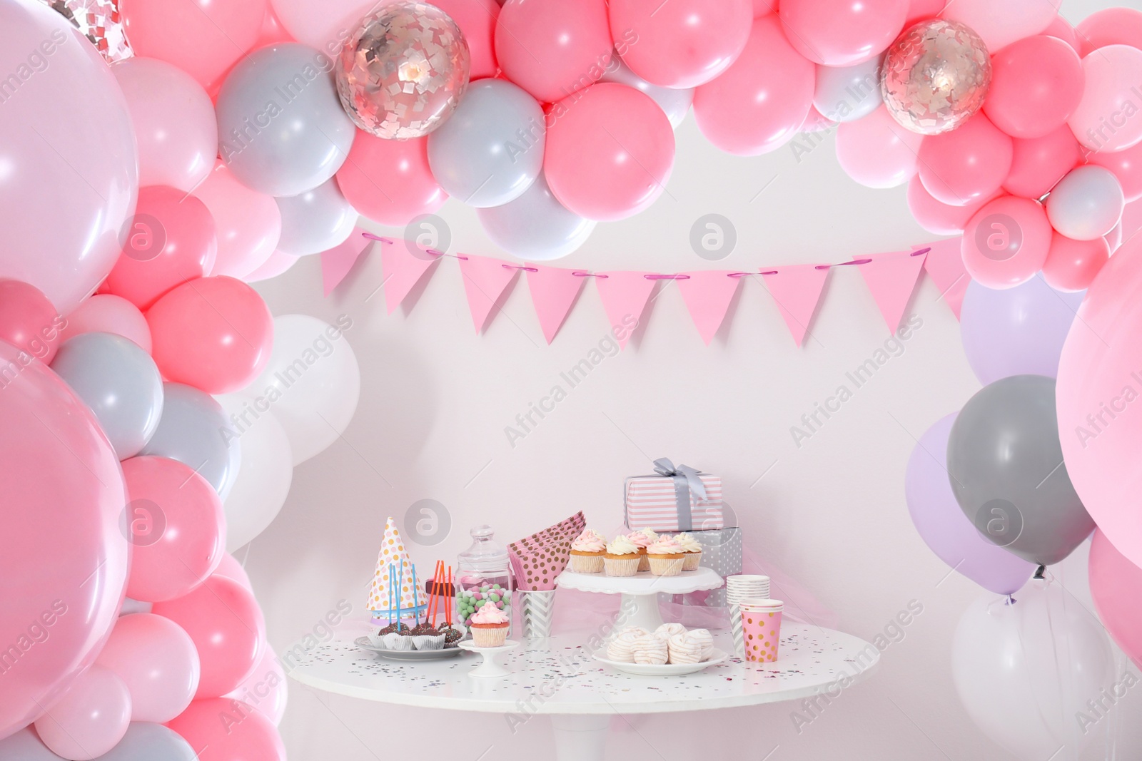 Image of Baby shower party for girl. Tasty treats on table in room decorated with balloons