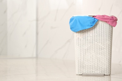 Laundry basket with dirty clothes on floor in room, space for text