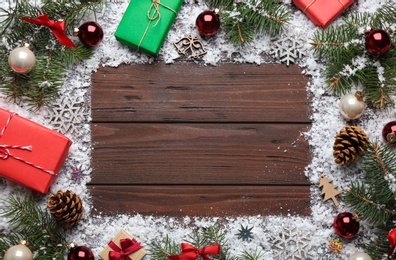 Frame made of Christmas decorations on wooden background, top view with space for text. Winter season