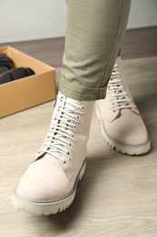 Woman wearing stylish leather boots indoors, closeup