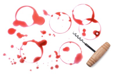 Red wine rings with drops and corkscrew on white background, top view