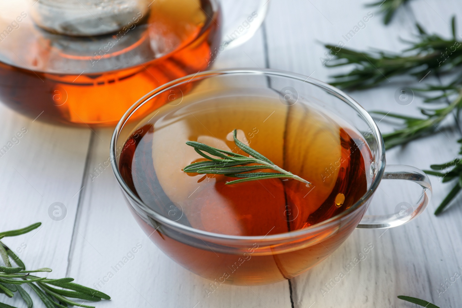 Photo of Aromatic herbal tea with rosemary on white wooden table