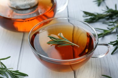 Aromatic herbal tea with rosemary on white wooden table