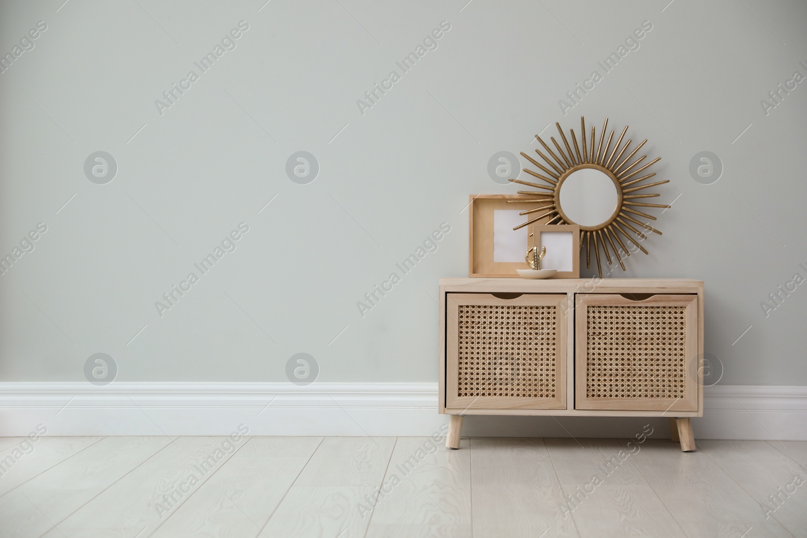 Photo of Stylish room interior with wooden cabinet near grey wall. Space for text