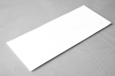 Photo of Blank palm card on light grey stone background, closeup. Mock up for design