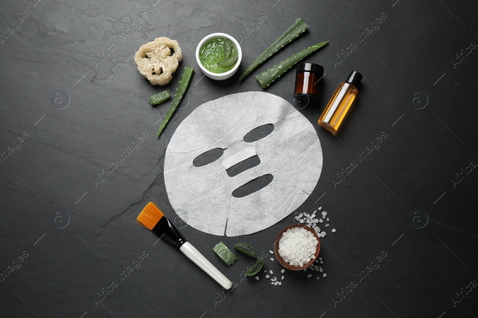 Photo of Flat lay composition with different cosmetic products and aloe on black table