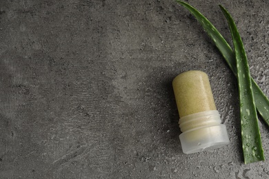 Photo of Natural crystal alum deodorant and aloe on grey table, flat lay. Space for text