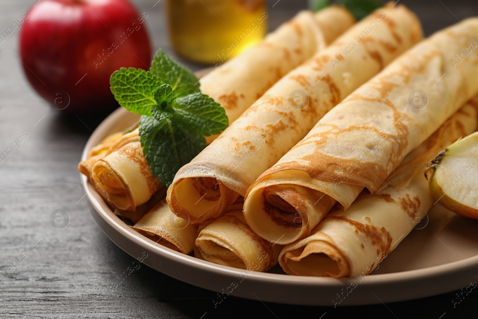 Photo of Delicious rolled  thin pancakes on wooden table, closeup