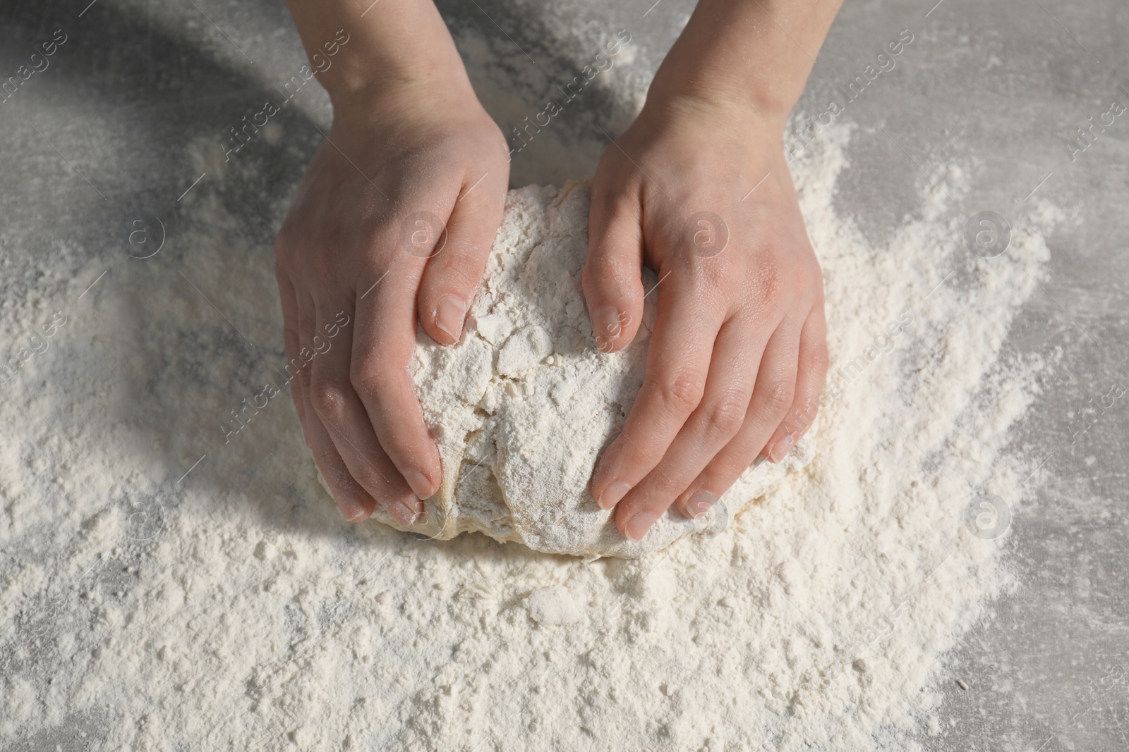 Photo of Making bread. Woman kneading dough at table, closeup