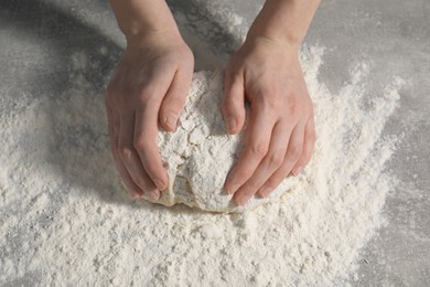 Making bread. Woman kneading dough at table, closeup