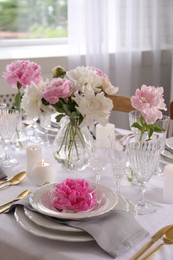 Stylish table setting with beautiful peonies in dining room