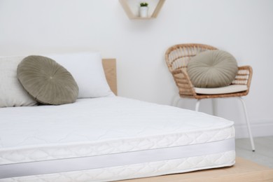 Photo of Wooden bed with soft white mattress and pillows indoors