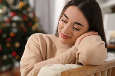 Photo of Christmas mood. Beautiful woman resting in cosy room