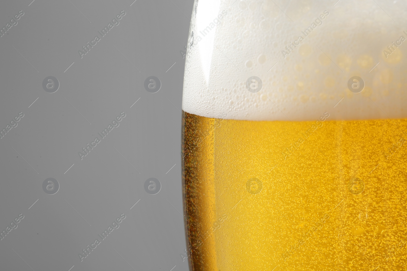 Photo of Glass of tasty beer with foam on color background, closeup