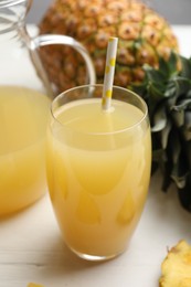 Delicious fresh pineapple juice on white wooden table, closeup
