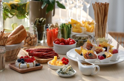 Variety of snacks on wooden table in buffet style indoors