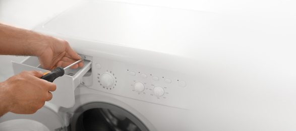 Image of Professional plumber repairing broken washing machine, space for text. Banner design