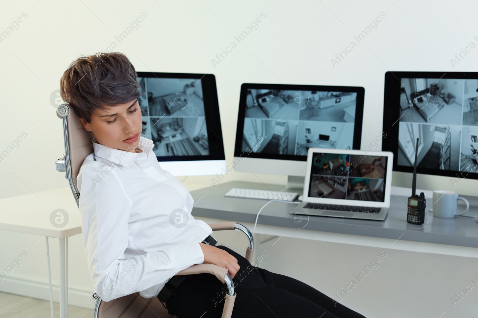 Photo of Female security guard sleeping at workplace indoors