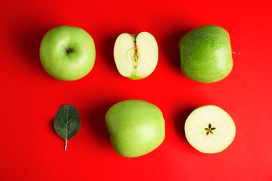 Flat lay composition of fresh ripe green apples on red background