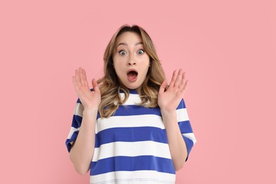 Portrait of surprised woman on pink background