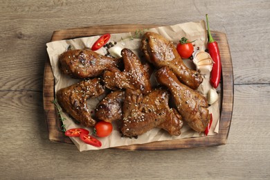 Photo of Tasty chicken glazed in soy sauce served on wooden table, top view