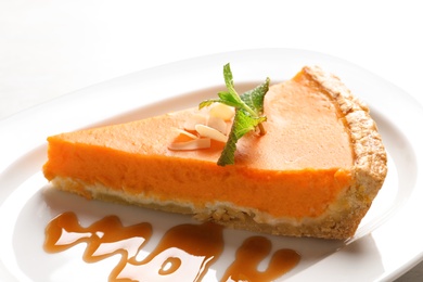 Plate with piece of fresh delicious homemade pumpkin pie on table, closeup