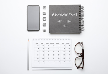 Image of Calendar, notebook, glasses and mobile phone on white background, top view. Counting days of quarantine during coronavirus outbreak 