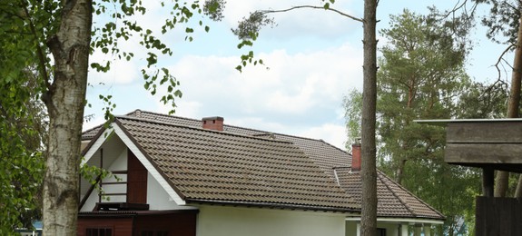 Photo of Modern building with brown roof outdoors on spring day