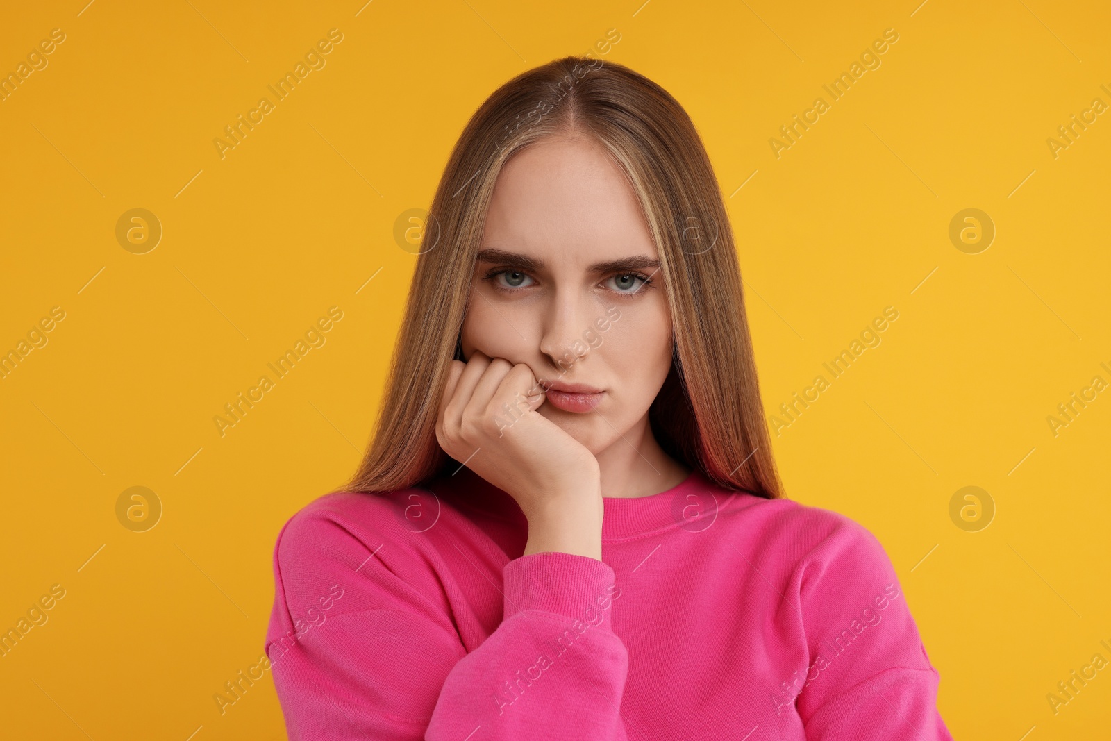 Photo of Portrait of resentful woman on orange background