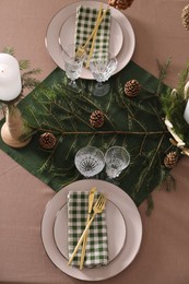 Photo of Christmas table setting with burning candle and festive decor, above view