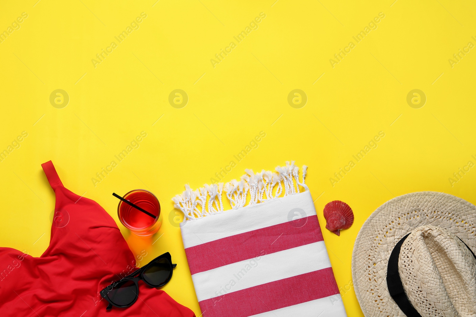 Photo of Beach towel, swimsuit, straw hat and sunglasses on yellow background, flat lay. Space for text