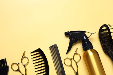 Hairdressing tools on yellow background, flat lay. Space for text