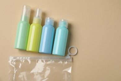 Cosmetic travel kit and plastic bag on beige background, flat lay with space for text. Bath accessories