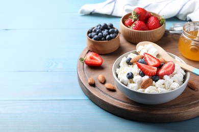 Photo of Bowl of fresh cottage cheese, berries with almond and ingredients on turquoise wooden table. Space for text