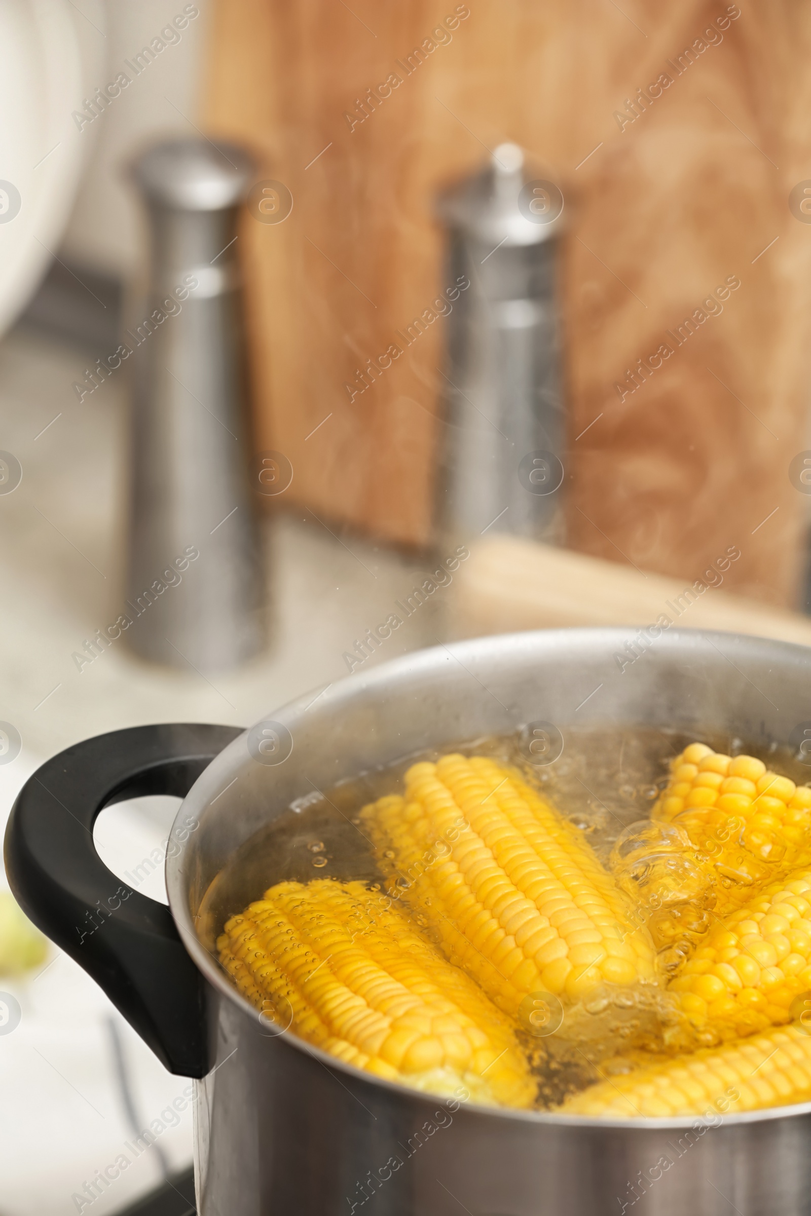 Photo of Stewpot with boiling water and corn cobs, closeup. Space for text