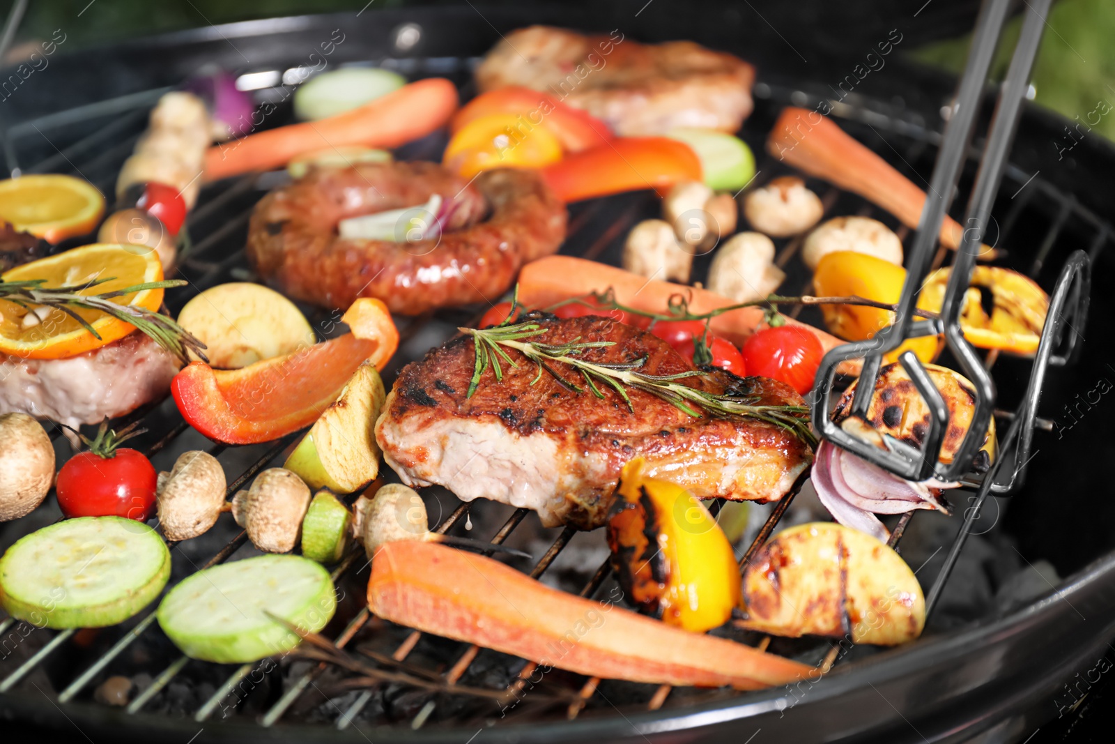 Photo of Barbecue grill with delicious cooked meat and vegetables, closeup