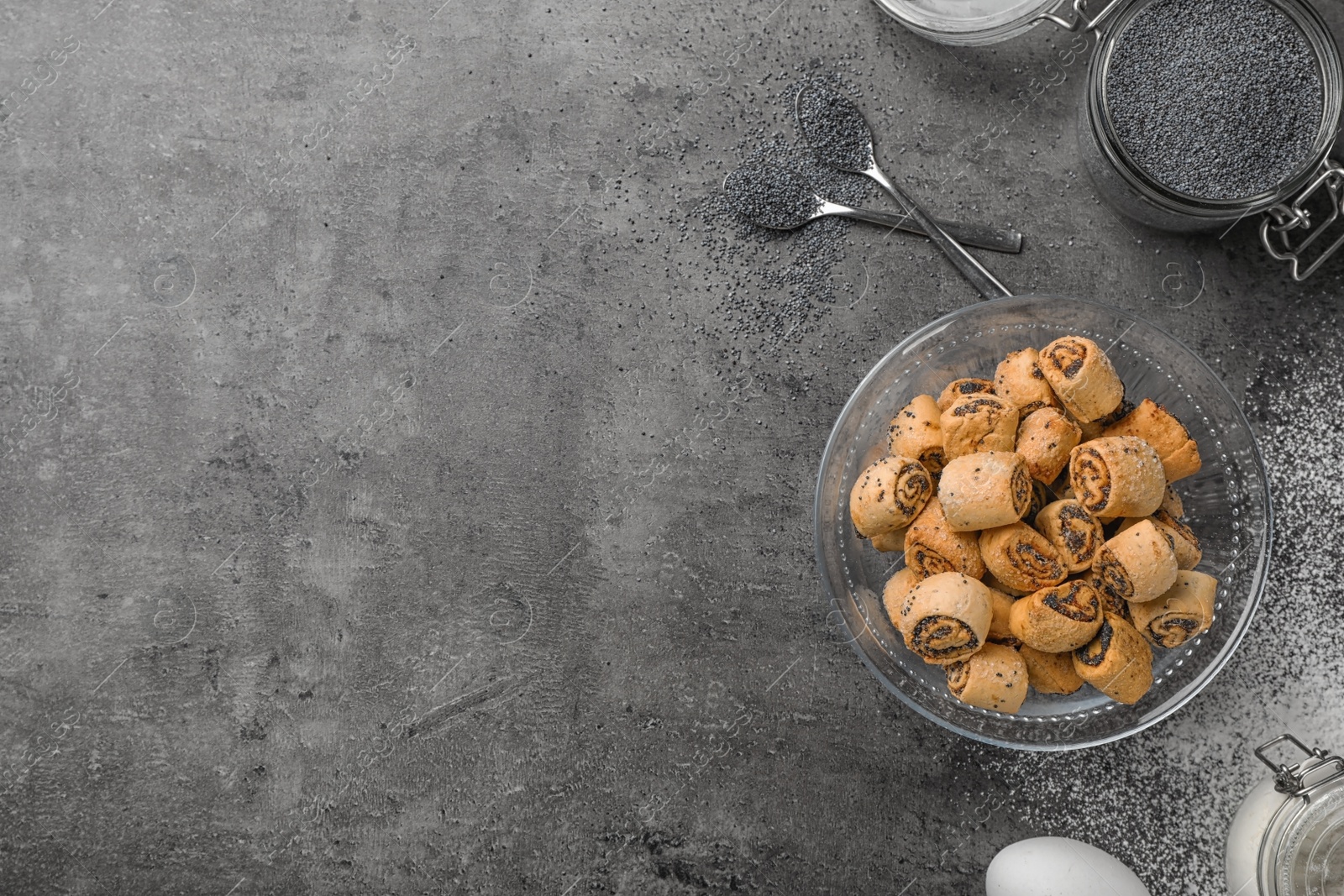 Photo of Tasty sweet cookies with poppy seeds on gray table, flat lay. Space for text