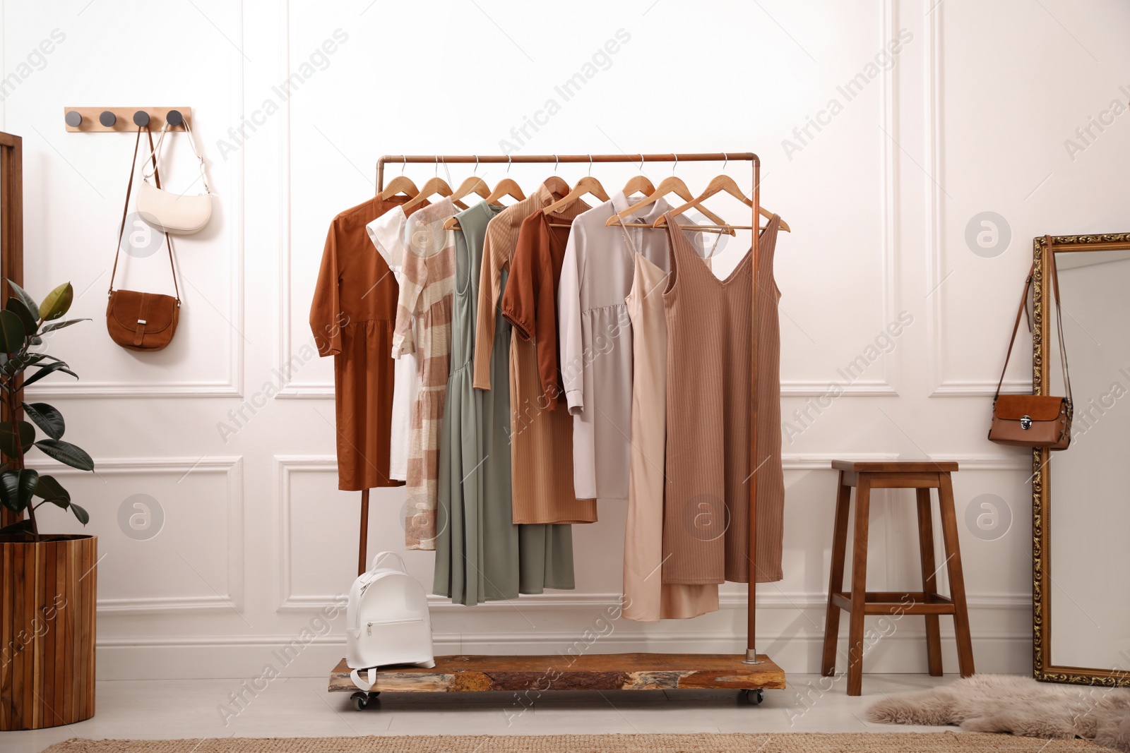 Photo of Stylish clothes hanging on rack in dressing room. Interior design
