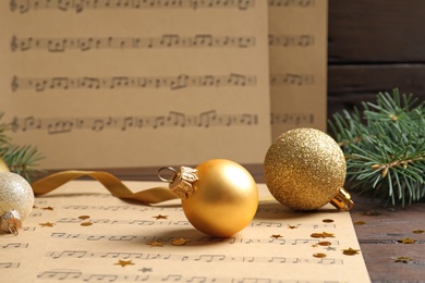 Photo of Composition with Christmas decorations and music sheets on table
