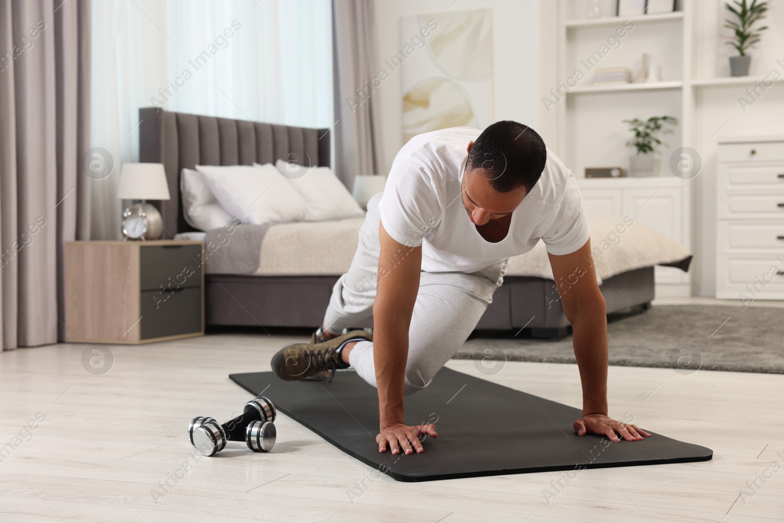 Photo of Man doing morning exercise on fitness mat at home