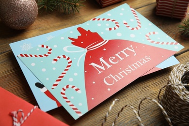 Christmas cards and festive decor on wooden background, closeup