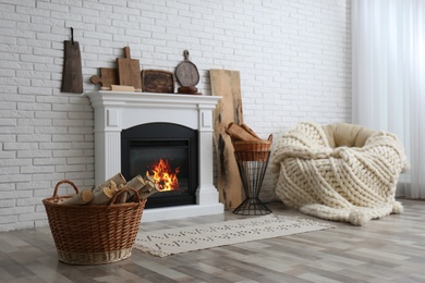 Photo of Wicker baskets with firewood and white fireplace in cozy living room