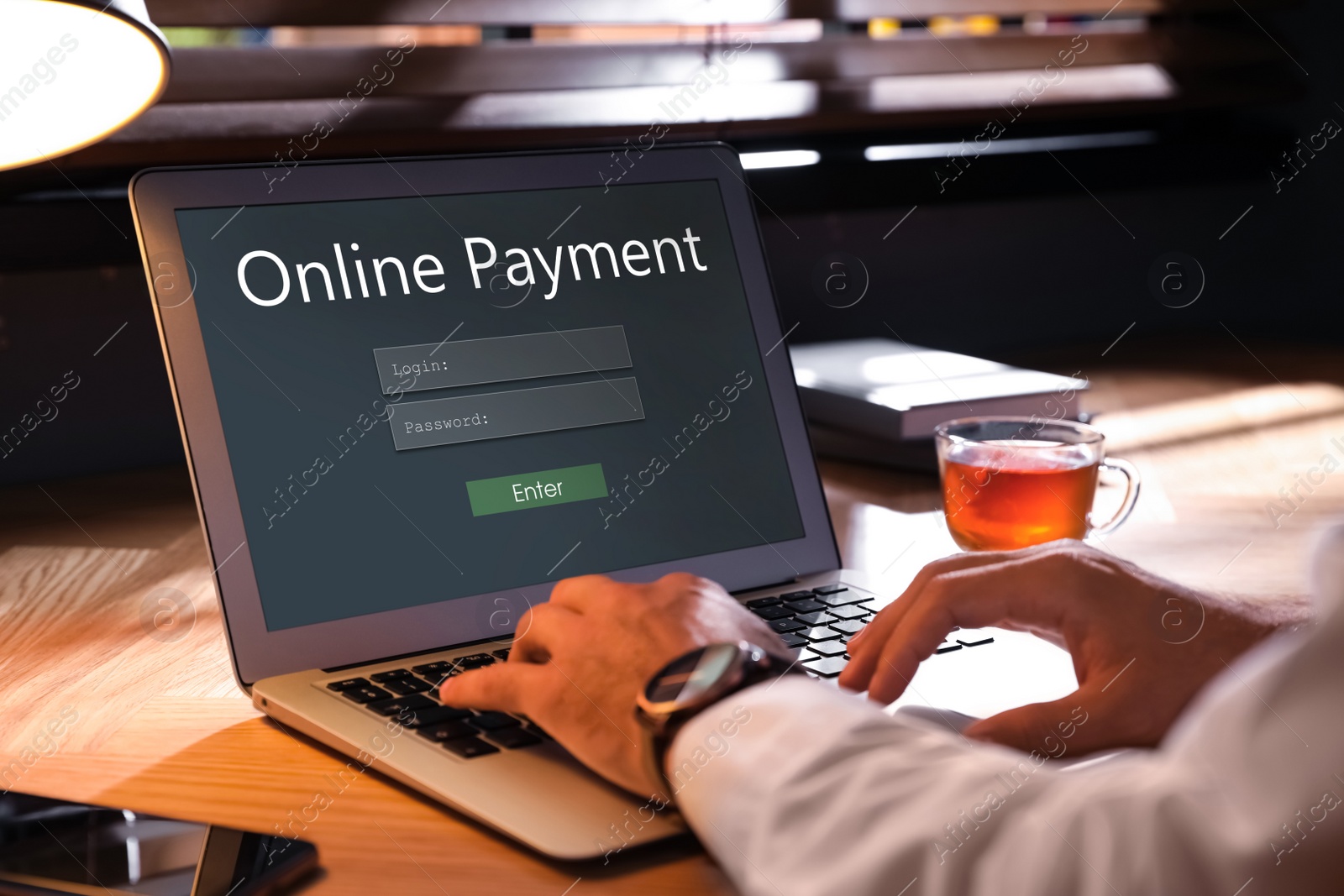 Image of Man using laptop for online payment at table, closeup